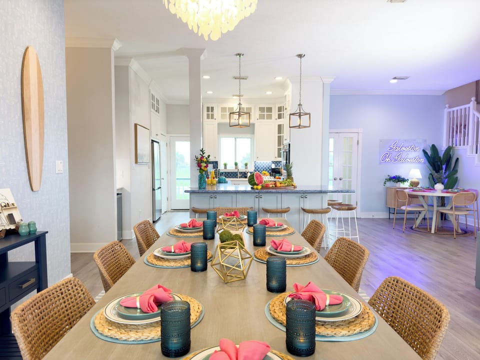 Spacious dining and living space with modern coastal furnishings, open floor plan, and stylish lighting throughout the beach home.