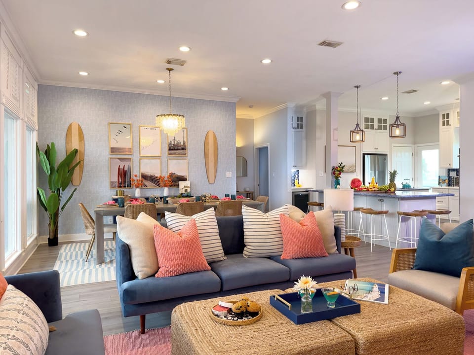 Spacious open-concept living area with modern kitchen, plush seating, and coastal décor ideal for large group vacations in Galveston.