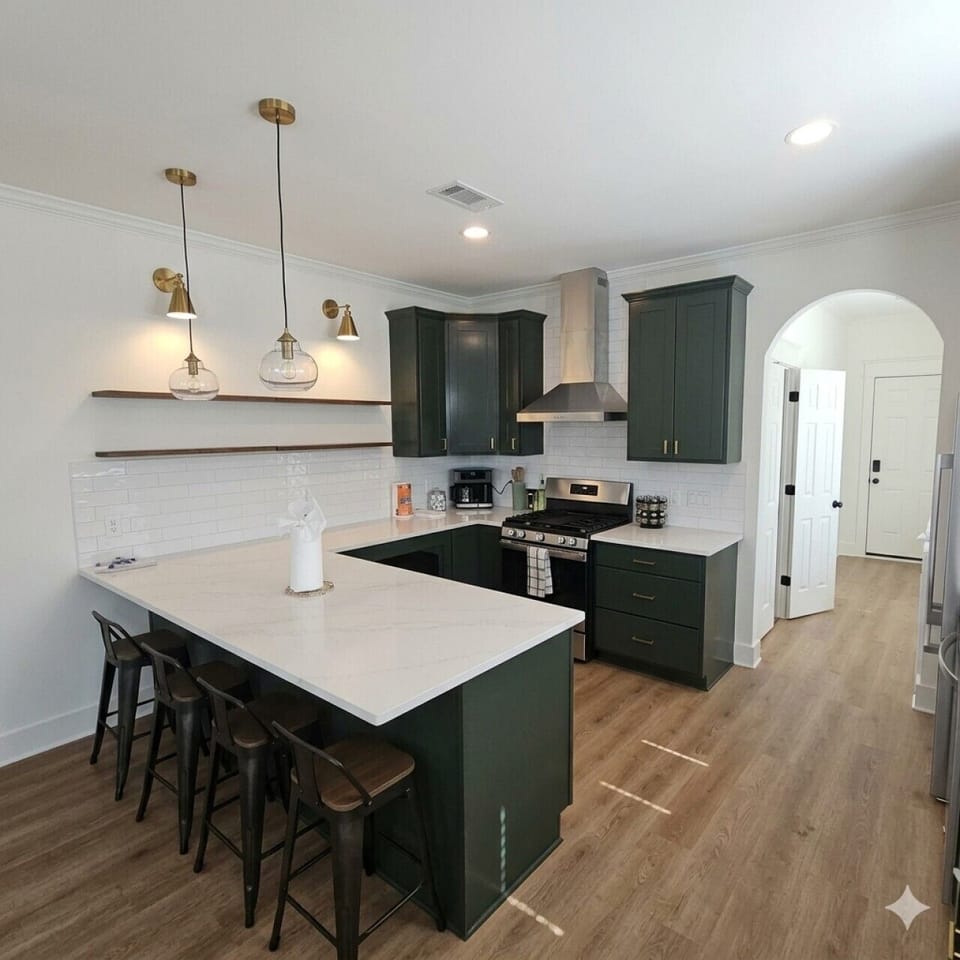 `Every detail was intentional — brass pendant lights, dark cabinetry, white quartz island, and an arched doorway that gives this kitchen serious character.`