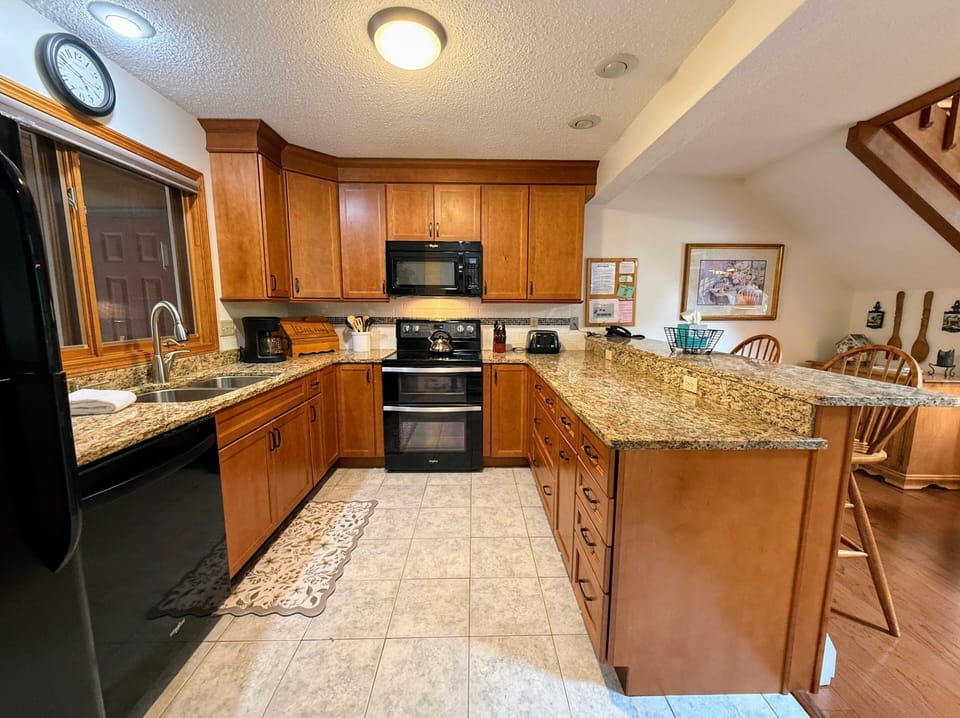Kitchen has standard appliances granite countertops and a breakfast bar.
