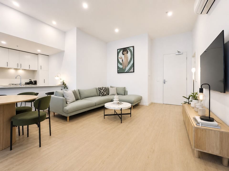 Bright modern living space with open kitchen, dining area, and comfy sofa