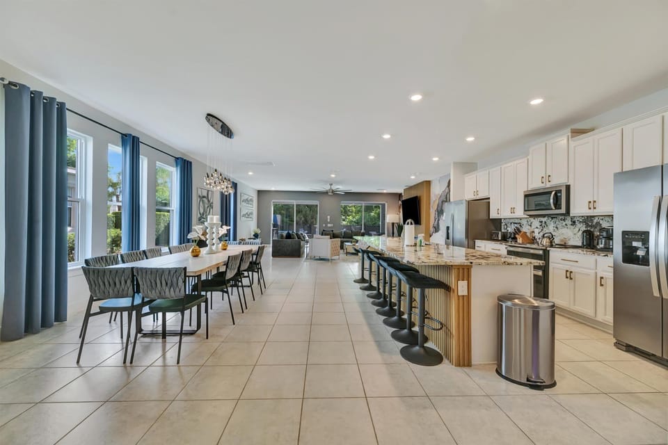 Open layout kitchen, dining, and living room area with breakfast bar, extended dining table, and plenty of space for 16+ guests 