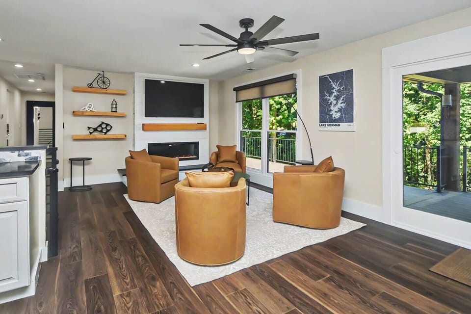 Bright living room with ceiling fan, fireplace, and lake views