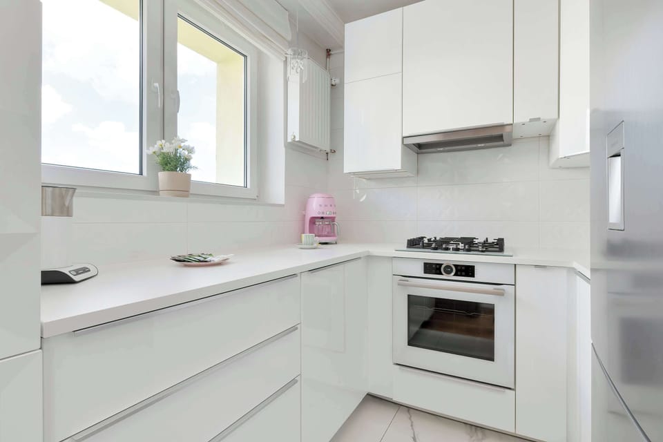 Another angle of the kitchen showcasing the stove, upper cabinets, and streamlined workspace.
