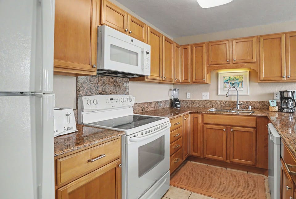 Your fully-equipped kitchen features granite counters, warm wood cabinetry, and modern appliances—perfect for whipping up vacation meals or your morning coffee.