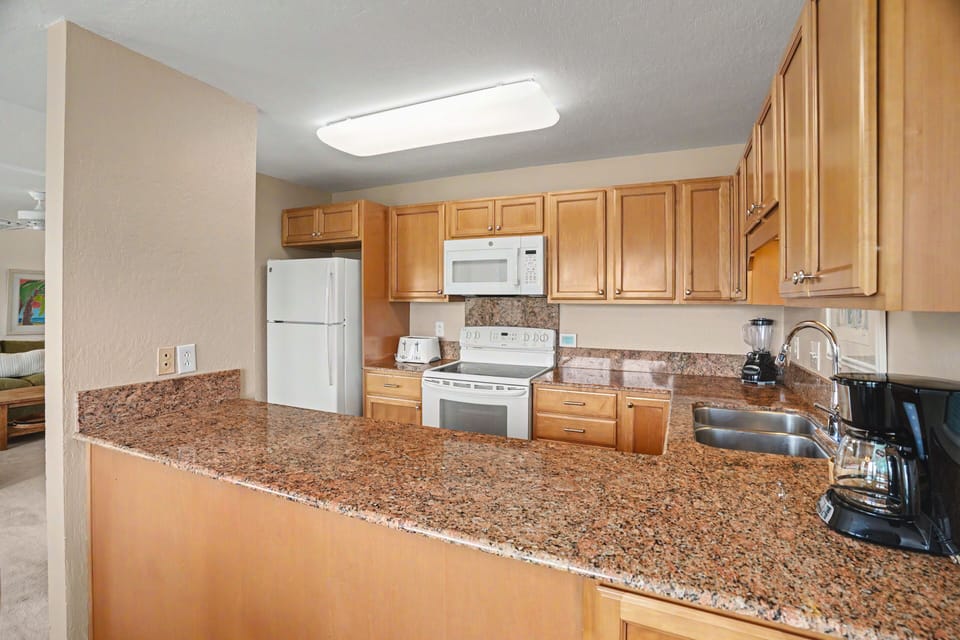 Your fully equipped kitchen offers ample counter space, modern appliances, and warm wood cabinetry—perfect for preparing meals or brewing morning coffee during your stay.