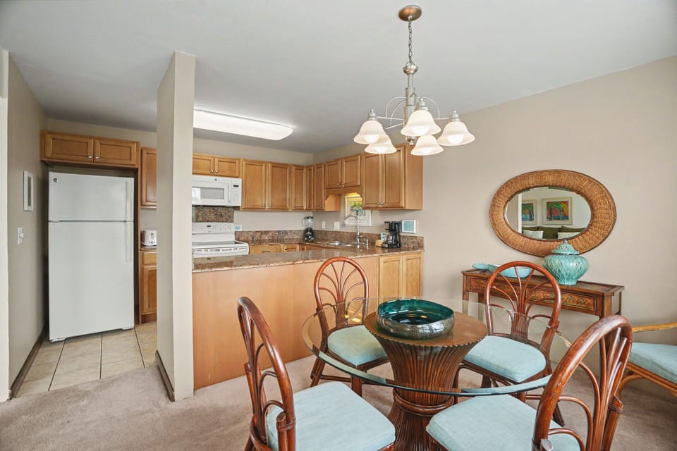 Your open-plan kitchen and dining area features warm wood cabinetry, granite countertops, and a charming round table where you can enjoy home-cooked meals together in comfort and style.
