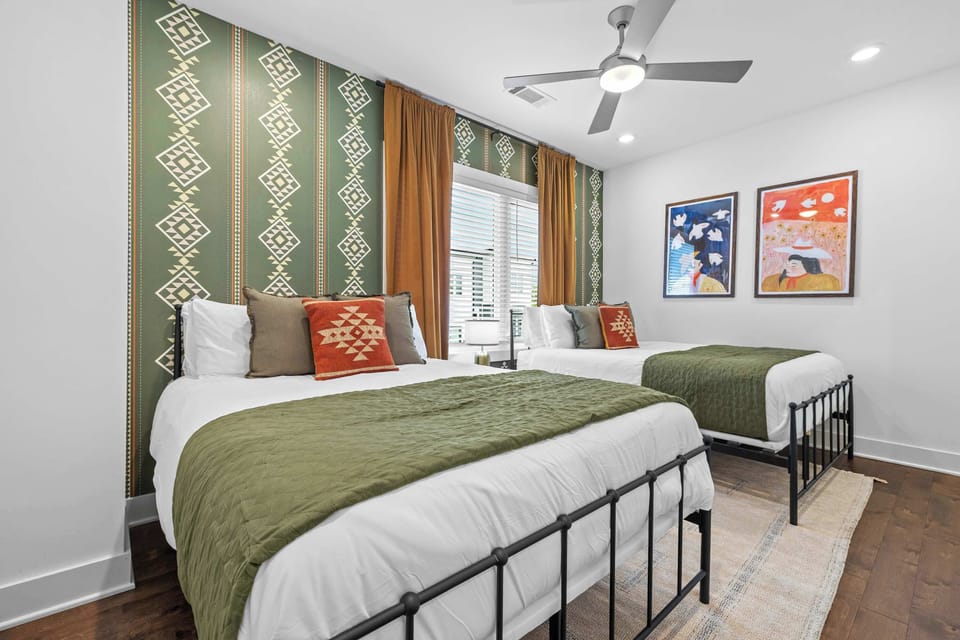 Guest bedroom with two queen beds and bold western-inspired décor