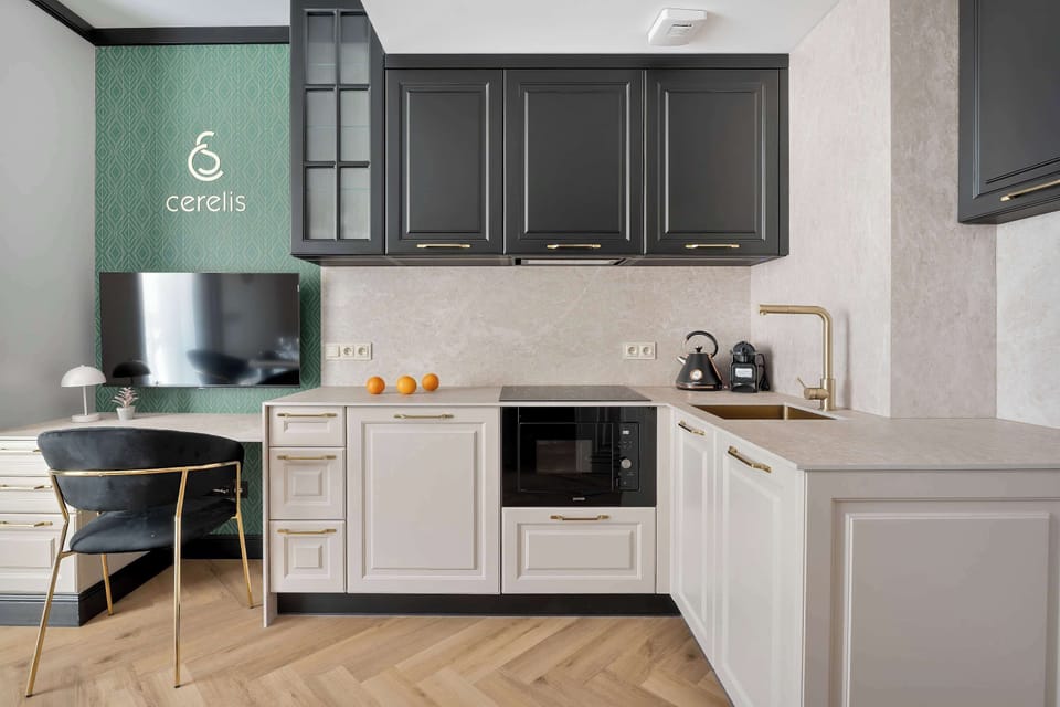 A sleek kitchenette with white cabinetry, a built-in microwave, and an induction cooktop. The minimalist design is complemented by integrated under-cabinet lighting.