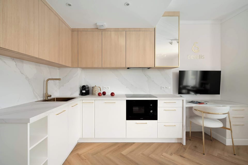 A light wood and white kitchenette installation with clean lines and integrated appliances. The bright materials create a fresh and inviting cooking environment.