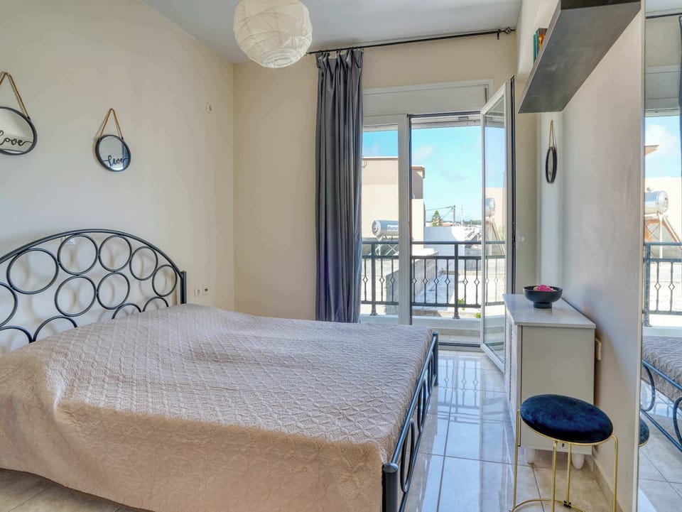 A bright second bedroom with direct access to the balcony creates a comfortable retreat after long days by the coast.