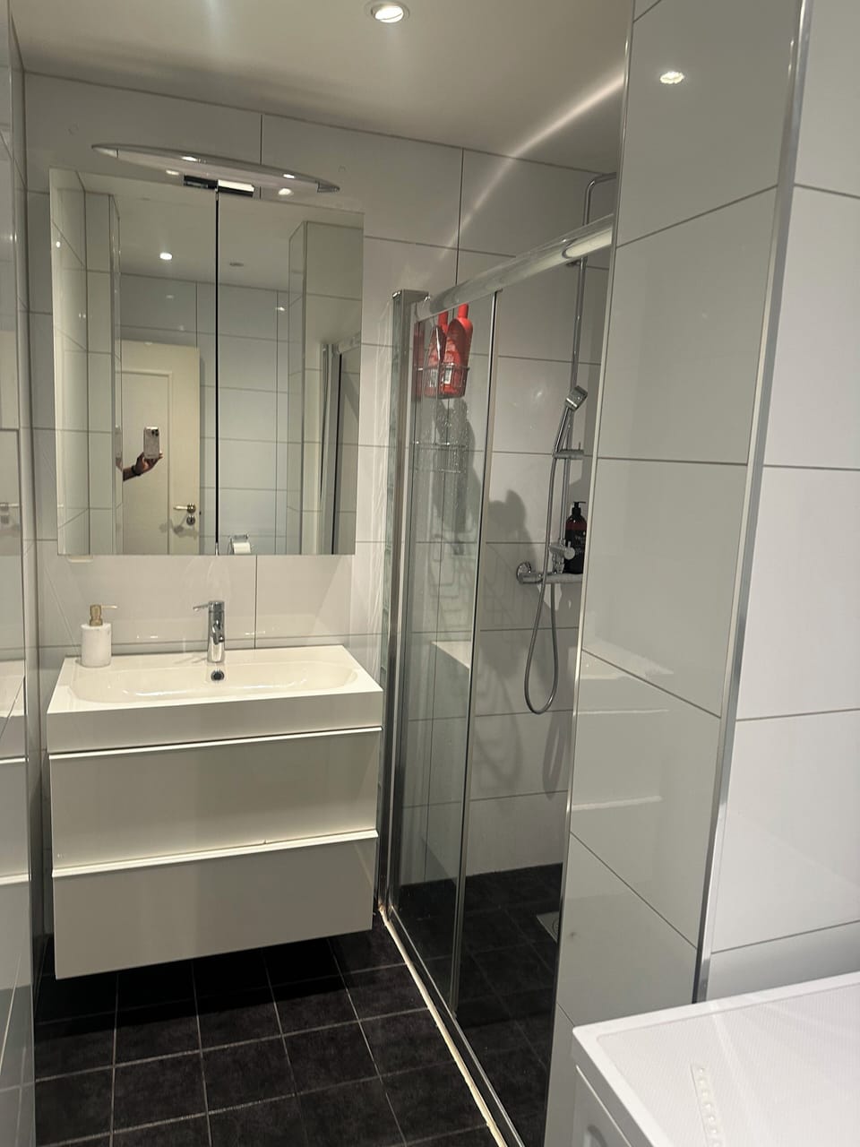 The bathroom with mirror  toilet papers,toothbrush ,brow dryer 