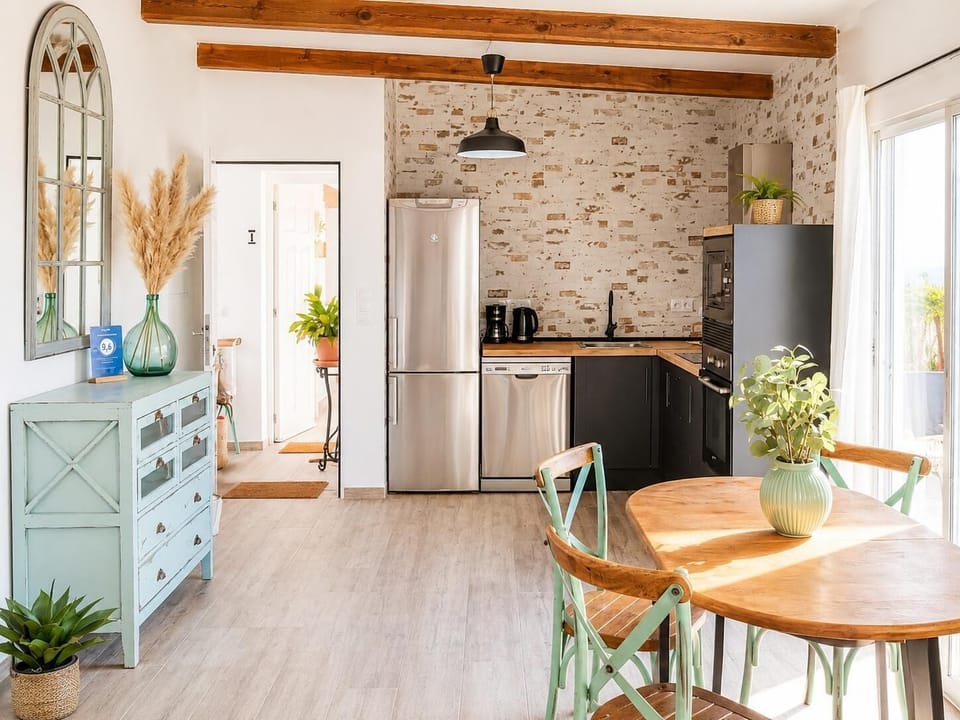Bright open-plan kitchen and dining area with rustic wooden beams and stylish natural decor.