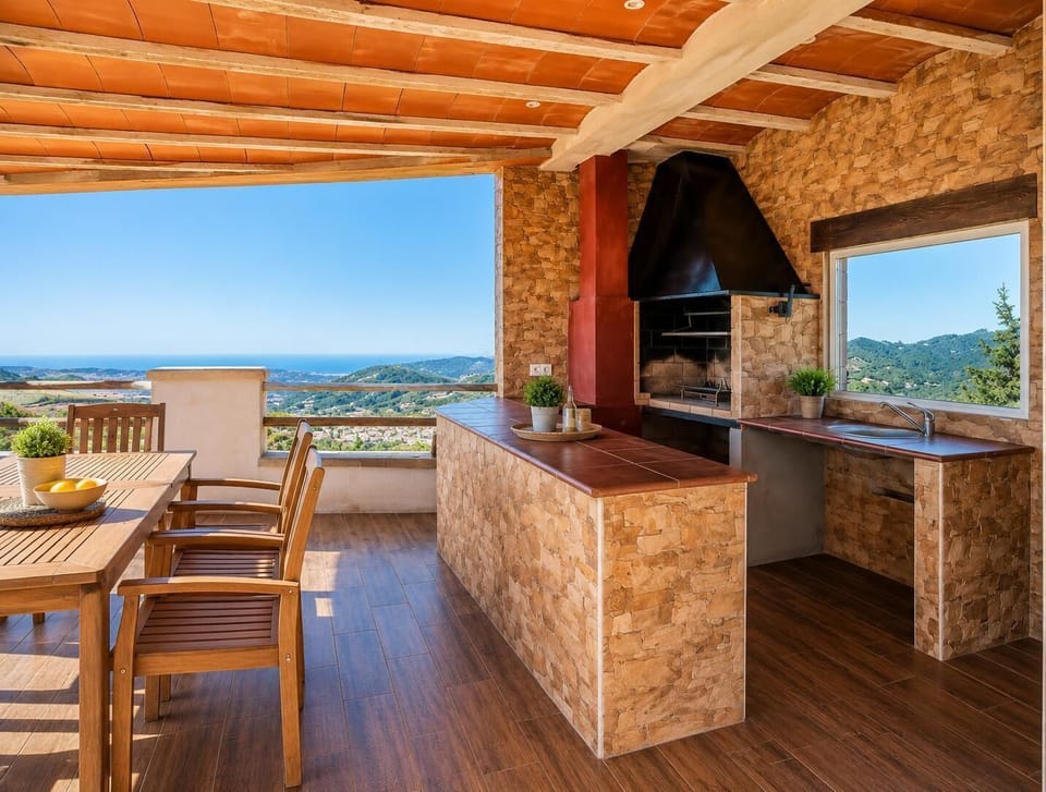 A spacious covered outdoor dining and barbecue area with stunning sea and hillside views.