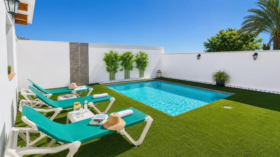 A sunny private pool area with turquoise loungers and a fresh tropical feel.