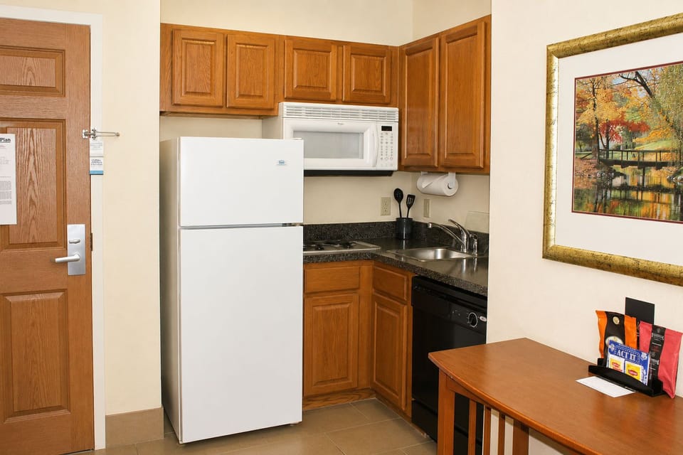 Full kitchen with refrigerator, stove, oven, microwave, and dishwasher — everything needed for a self-sufficient extended stay