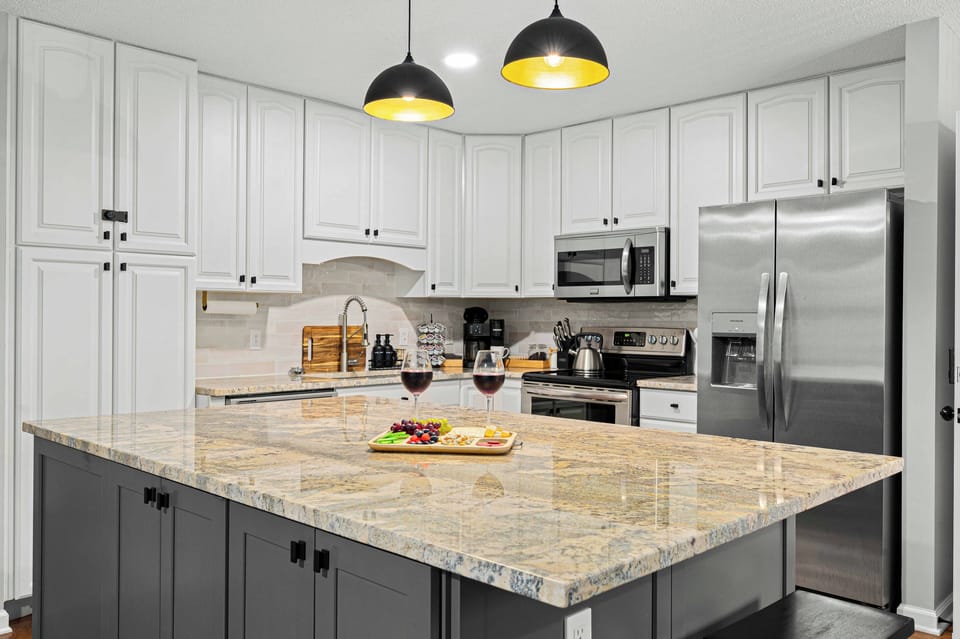 Gourmet Kitchen: Modern elegance with granite island and chic lighting — perfect for culinary adventures!