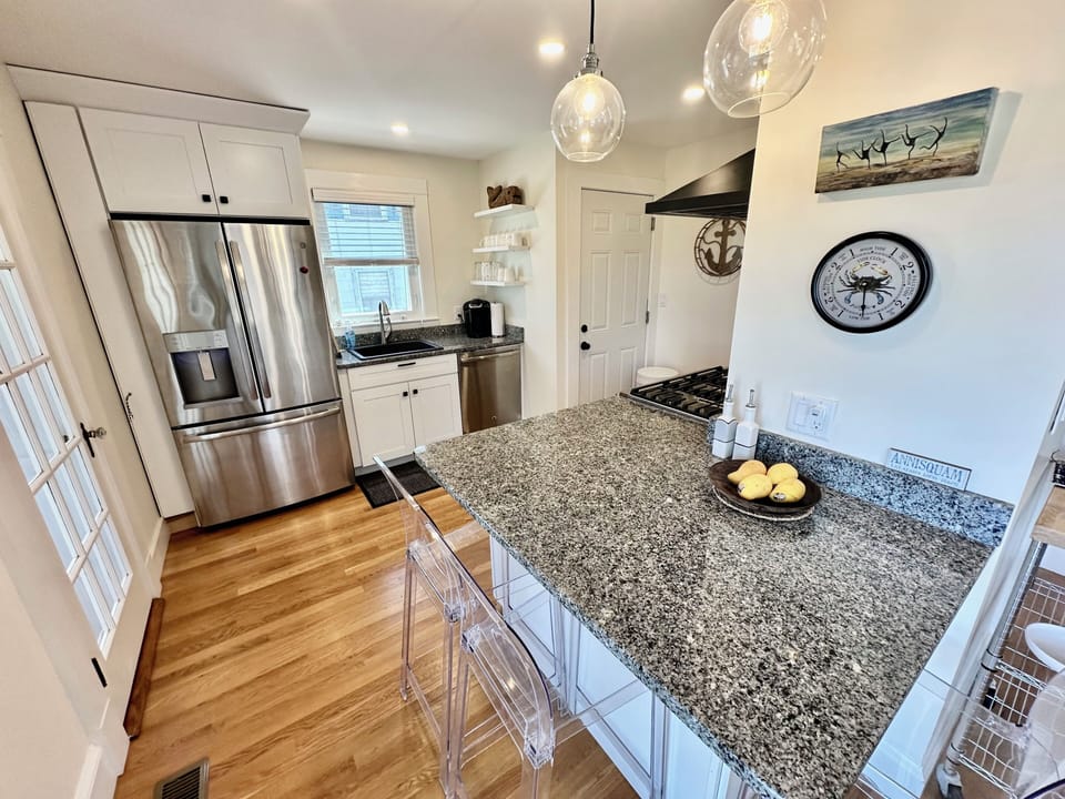 The kitchen includes a peninsula with bar chairs