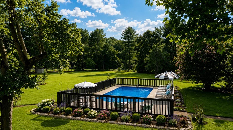 Private pool oasis with lush lawn, loungers, and serene wooded views