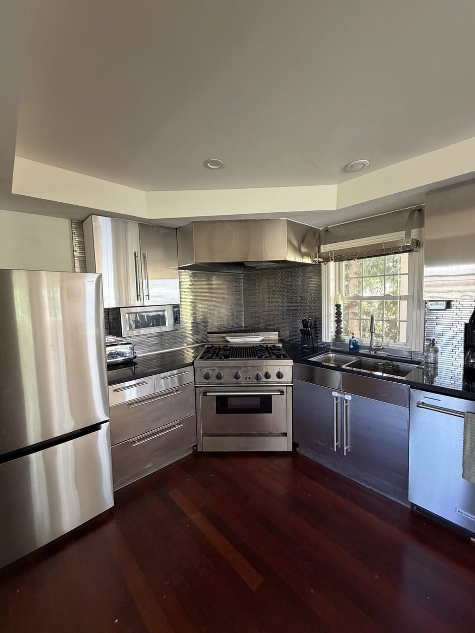 Modern chef’s kitchen with stainless appliances and sunlit window