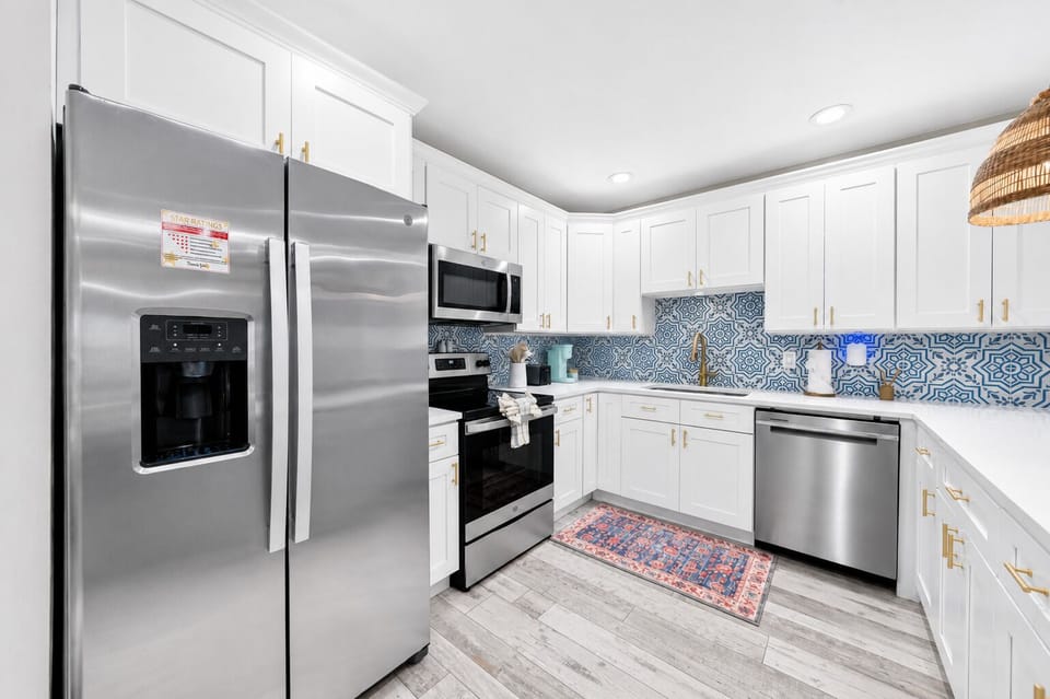Long view of the kitchen showcasing generous counter space, breakfast bar seating, and direct access to the dining area.