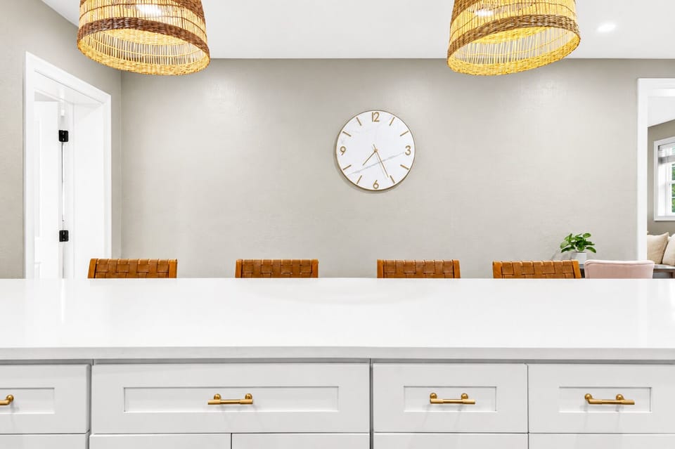 Reverse kitchen view highlighting extensive storage, bright open floor plan, and dining area beyond.