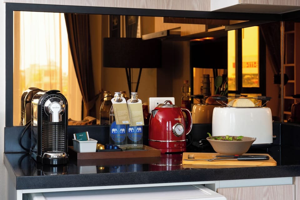 Modern in-room coffee station with kettle, toaster, and bottled water
