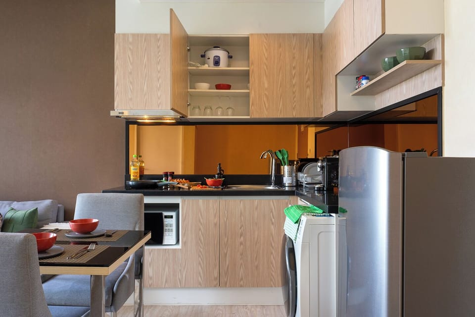 Modern kitchenette with dining nook, full-size fridge, and in-unit washer