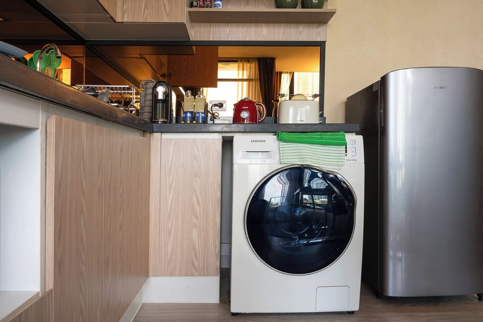 Compact kitchenette with in-unit washer, fridge, and coffee station