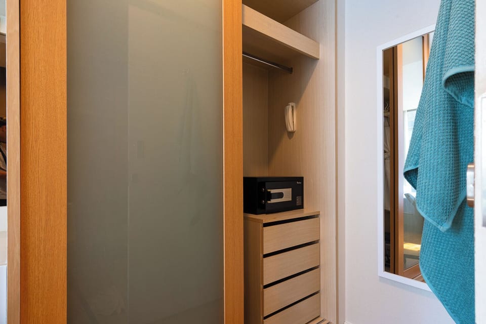 Organized closet with drawers, safe, and full-length mirror