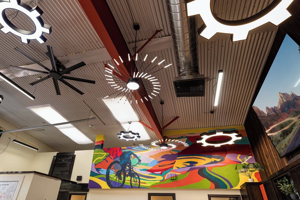 Experience the unique and artistic decor of Bike Barn, featuring a colorful bicyclist mural and themed lighting inspired by gears.