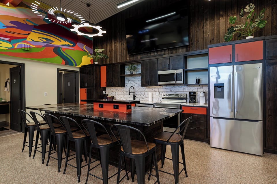 Spacious and vibrant kitchen at Bike Barn, Kanab, UT, featuring ample bar seating, modern appliances, and unique artistic touches.
