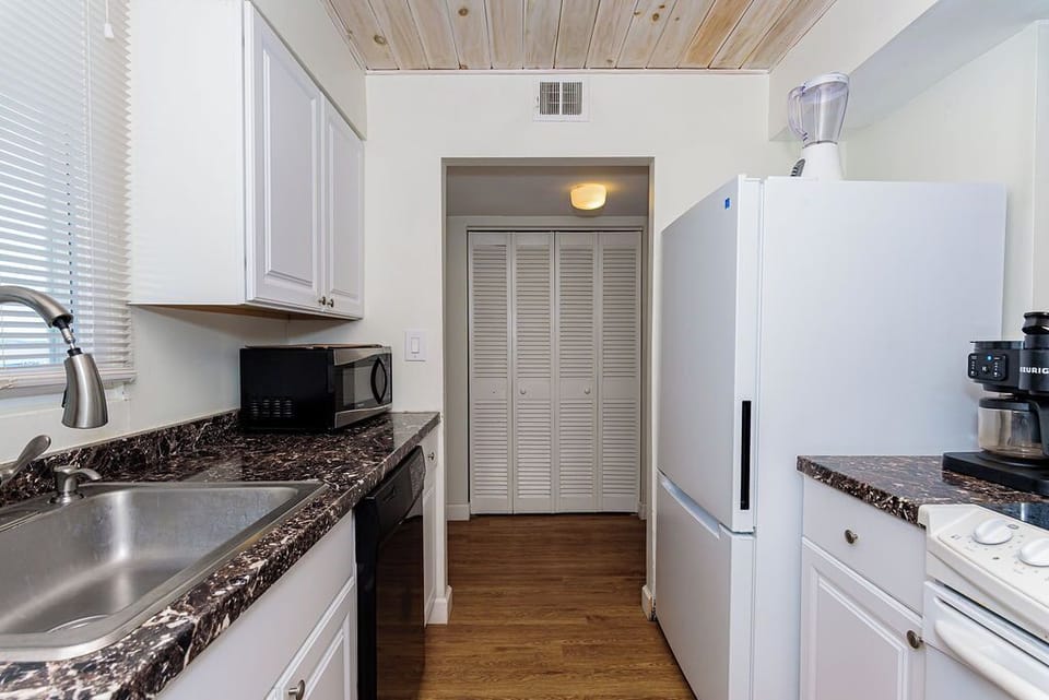 Bright galley kitchen with full appliances, pantry and coffee station