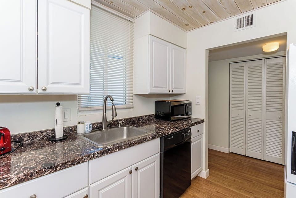 Bright kitchen with marble-look counters, dishwasher & pantry.