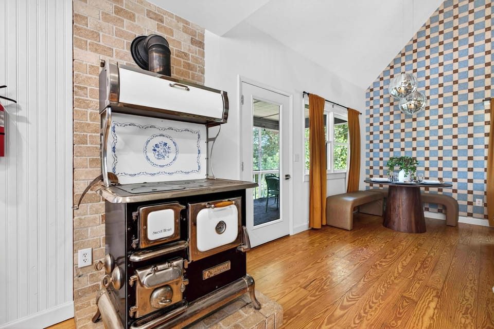 Step back in time with a modern twist! This stunning vintage-style stove adds the perfect touch of historic charm and character to our bright, open-concept dining area.
