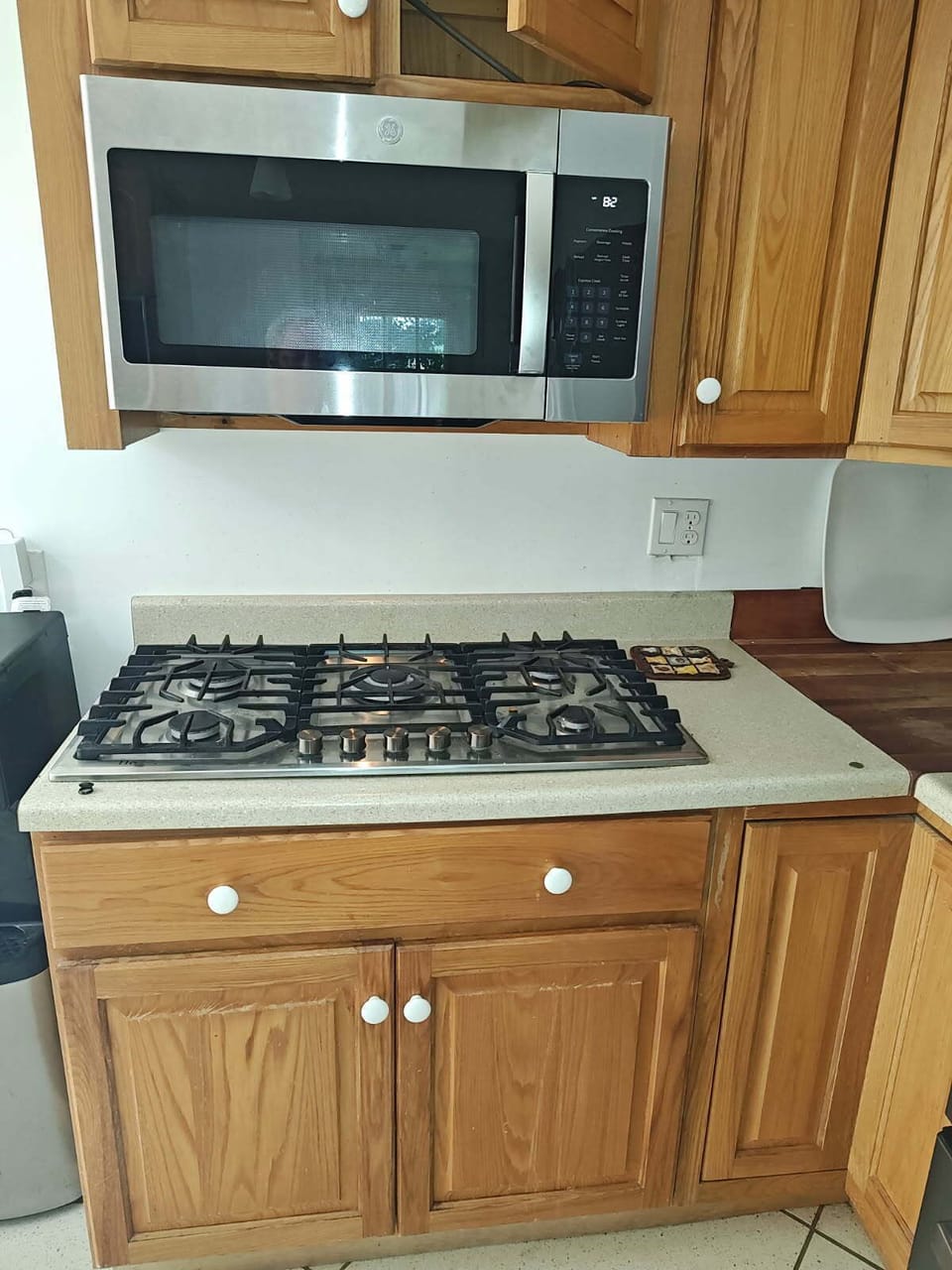 Stovetop and microwave in kitchen.