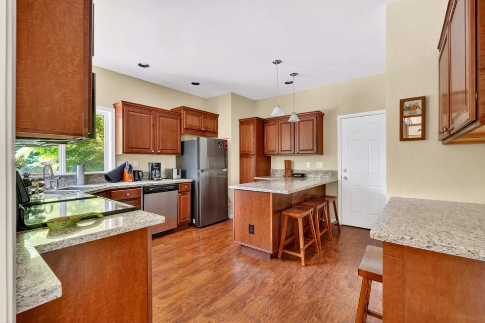 Kitchen with island seating and warm wood cabinets.