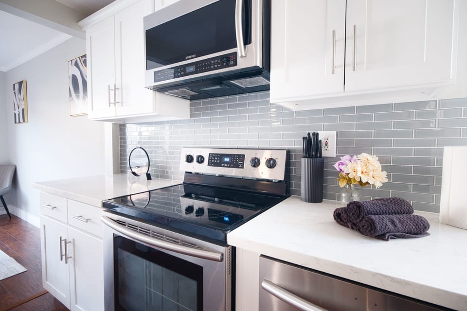 Bright modern kitchen with stainless appliances and quartz counters