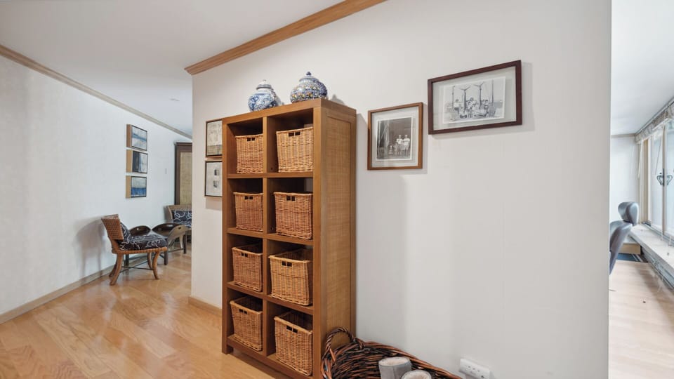 You'll love the thoughtful storage solutions here—wicker baskets in wooden cubbies keep your belongings organized, while warm hardwood floors and inviting decor create a calm, welcoming atmosphere.