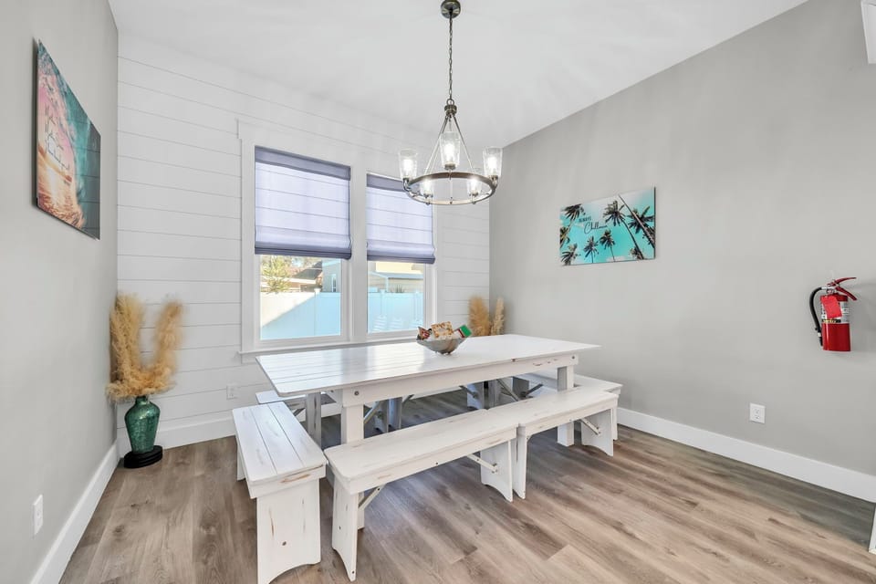 A white dining table, bright windows, and a living space that flows — this is where the group comes together for meals, games, and the kind of conversations that only happen on vacation.