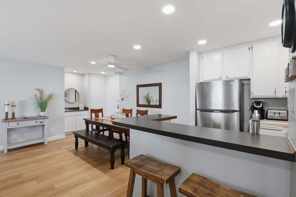 This bright, fully equipped kitchen makes meal prep a breeze. The space flows seamlessly into a dining area that seats 6, complemented by an additional 2 barstools at the central island.