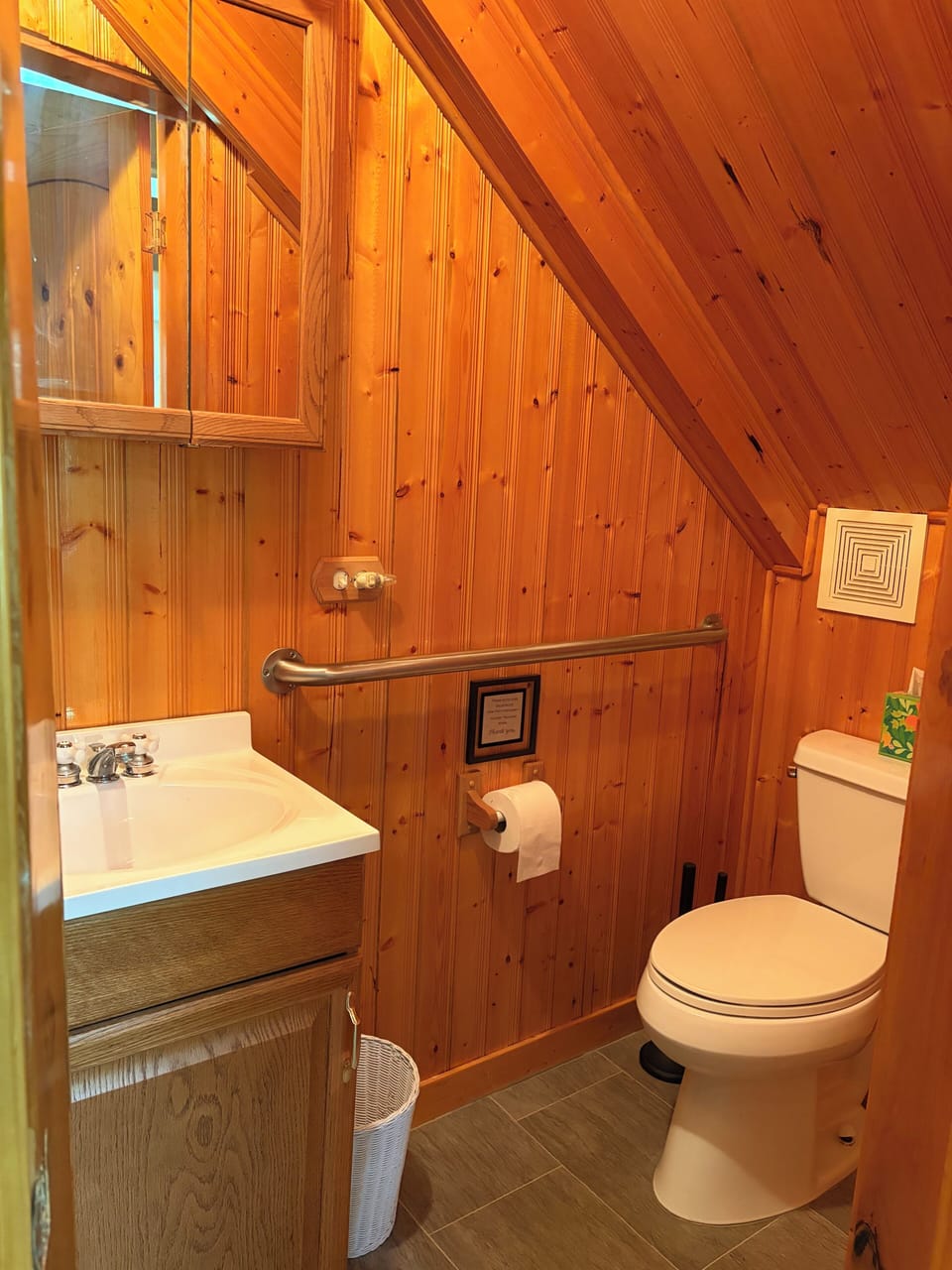Half bath off the Great Room has grab bars for stability & knotty pine paneling.