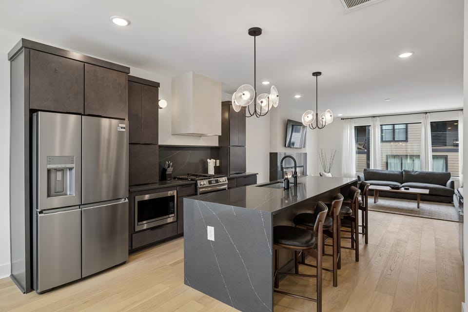 Kitchen: A stylish kitchen with an island, bar seating, and contemporary lighting.