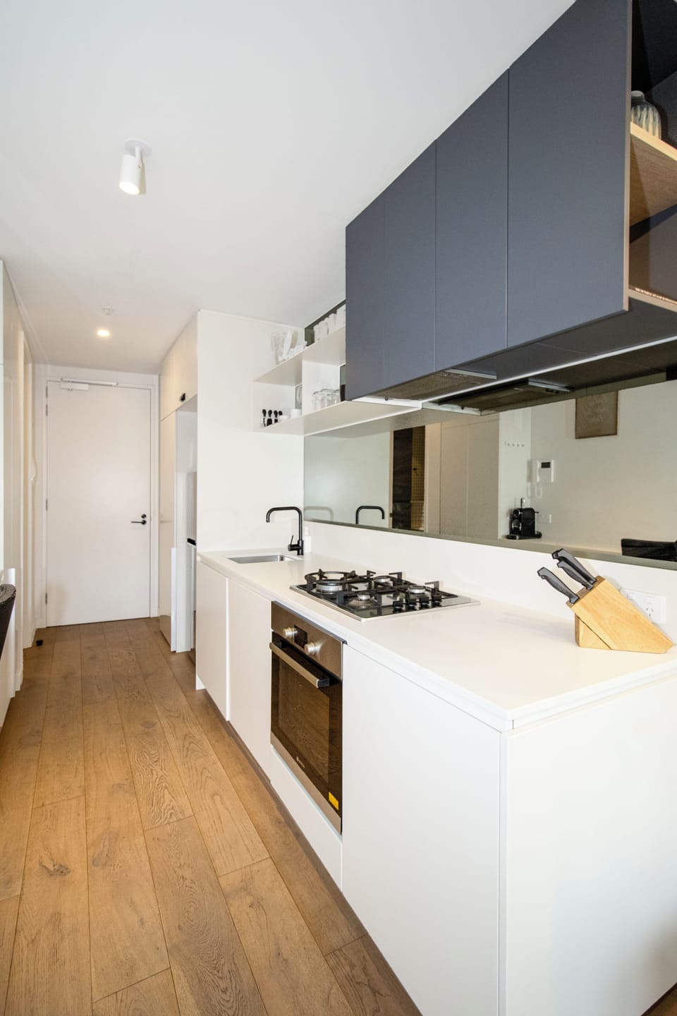 Sleek modern kitchen with gas cooktop, built-in oven, and clean design