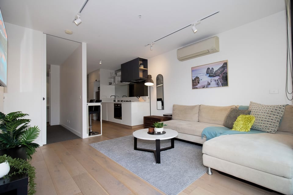 Bright open-plan living with comfy sectional, sleek kitchen, and modern style