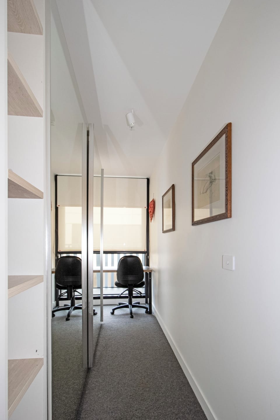 Bright nook with desk, mirrored storage, and built-in shelving
