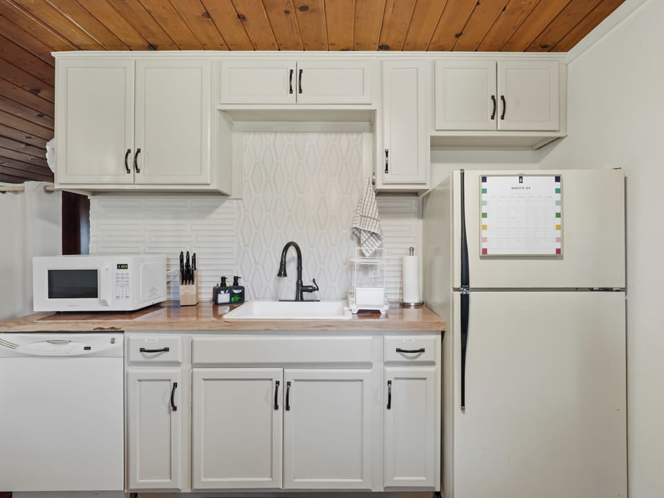 Bright full kitchen with farmhouse sink and charming wood accents