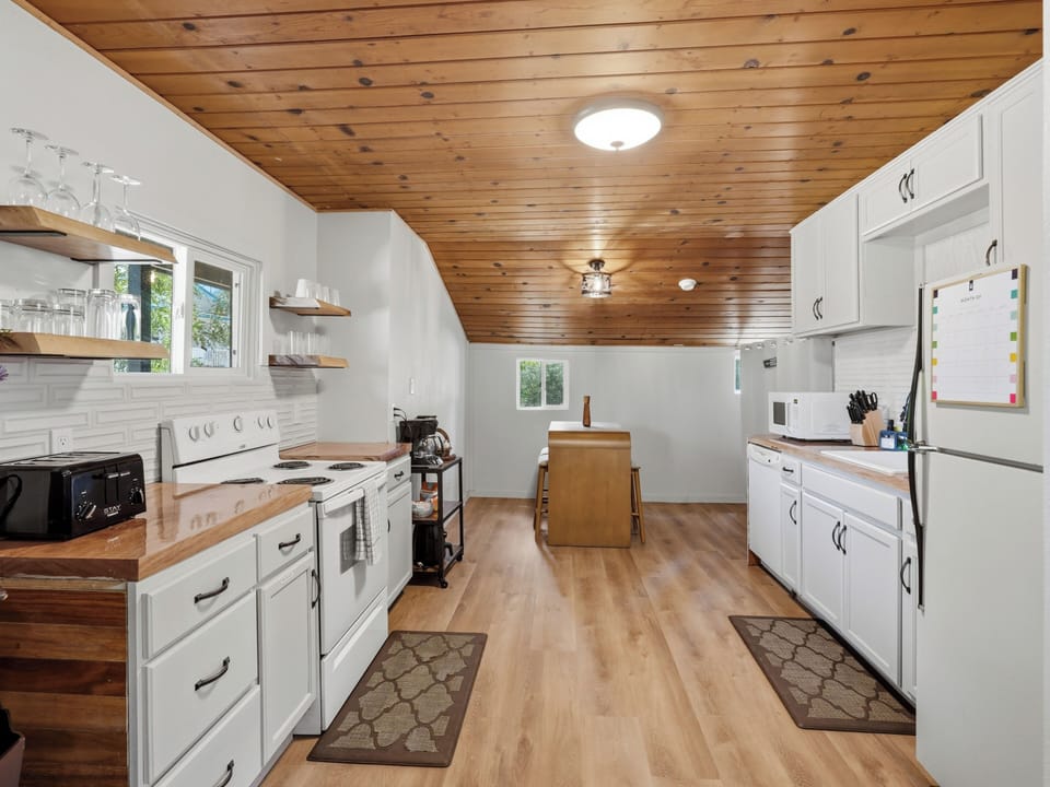 Bright farmhouse-style kitchen with island and warm wood ceilings