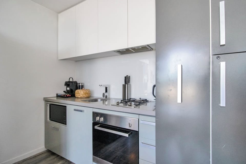Modern compact kitchen with full appliances and sleek storage