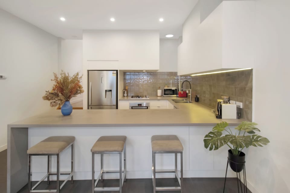 Modern open kitchen with breakfast bar seating for 3 and sleek finishes
